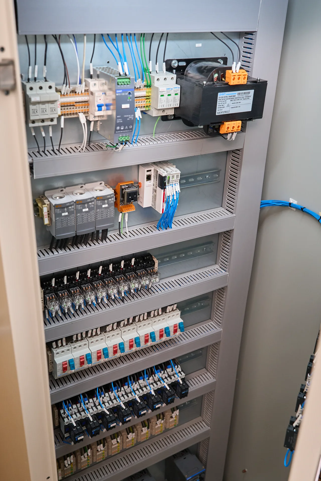 Panel eléctrico industrial con fuentes, controlador, relés y cableado identificado
